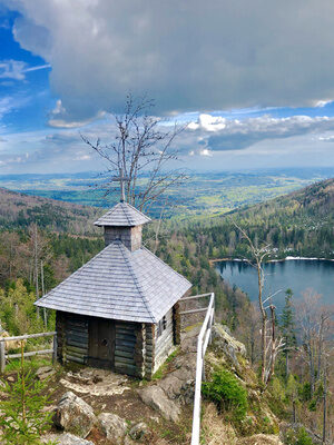 Ein malerischer Blick auf die Rachelkapelle im Nationalpark Bayerischer Wald mit See im Hintergrund